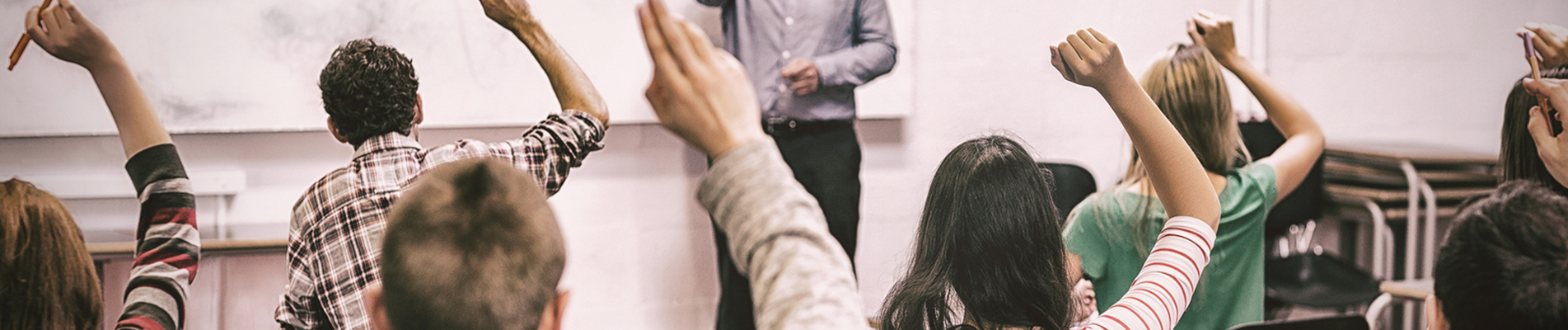 Students raising their hands in class